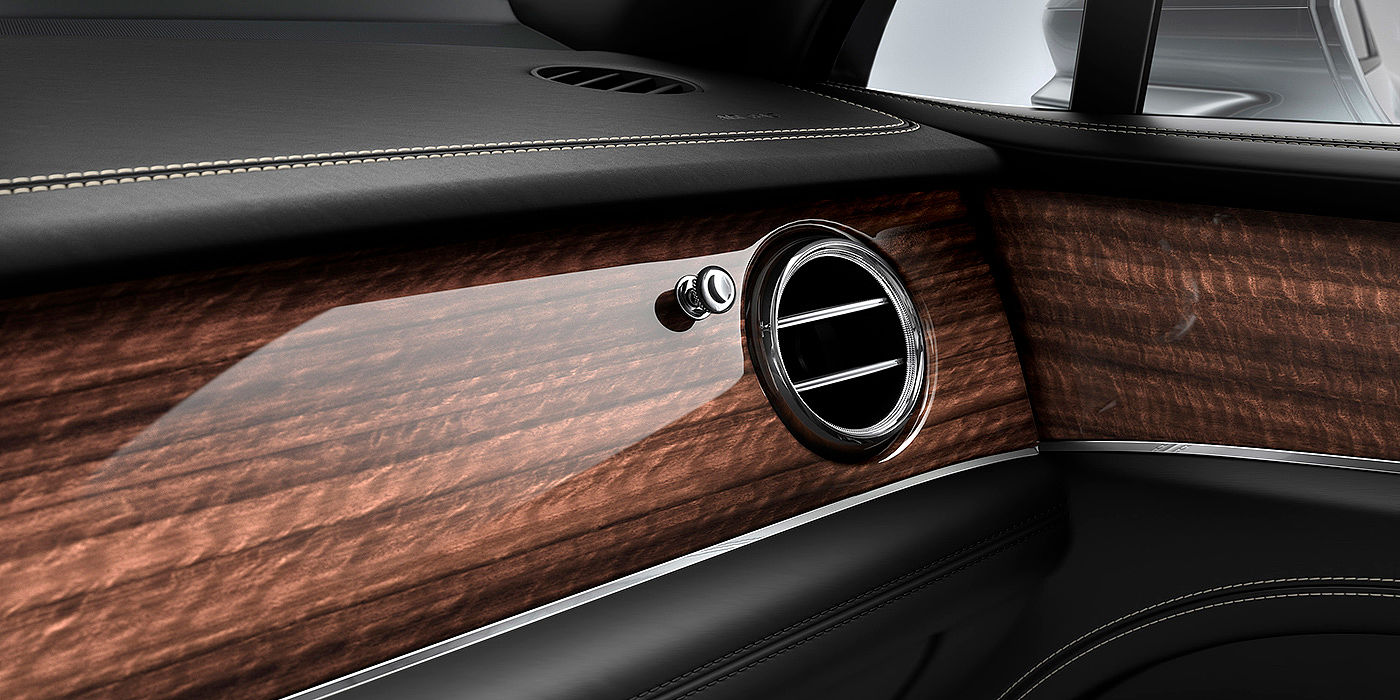 Bentley Warszawa Bentley Bentayga front interior Crown Cut Walnut veneer and chrome air vent.