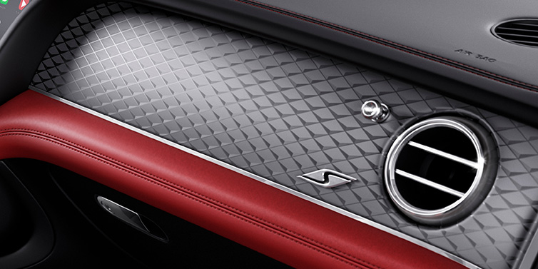 Bentley Warszawa Bentley Bentayga S SUV front interior dash with Dark Tint Diamond Brushed Aluminium veneer and S badge surrounded by Hotspur red and Beluga black hide