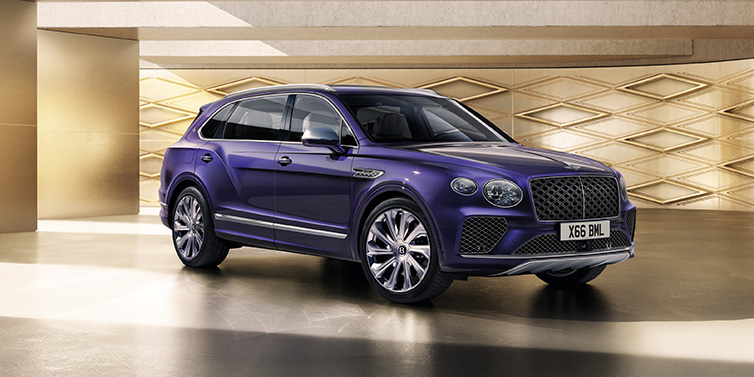 Bentley Warszawa Bentley Bentayga Extended Wheelbase Mulliner SUV front three quarter in Tanzanite Purple paint with a gold patterned background