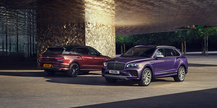 Bentley Warszawa A duo of Bentley Bentayga Extended Wheelbase Mulliner SUVs parked in a city environment, with Tanzanite Purple and Cricket Ball red exterior paint