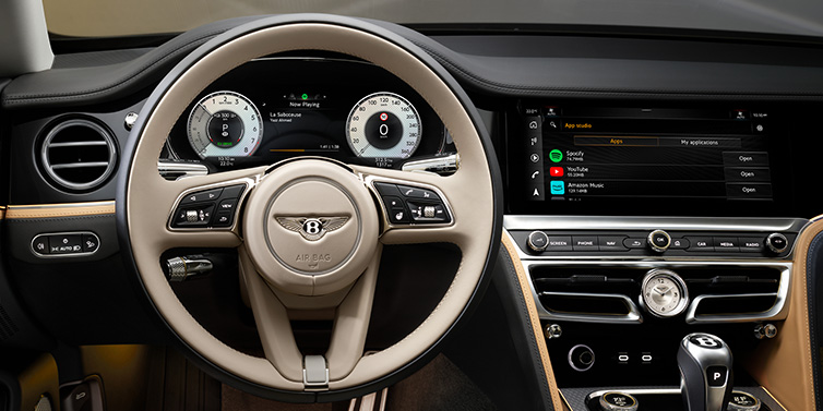 Bentley Warszawa Bentley Flying Spur Mulliner sedan front interior detail of steering wheel and driver screens surrounded by Linen and Beluga black hides